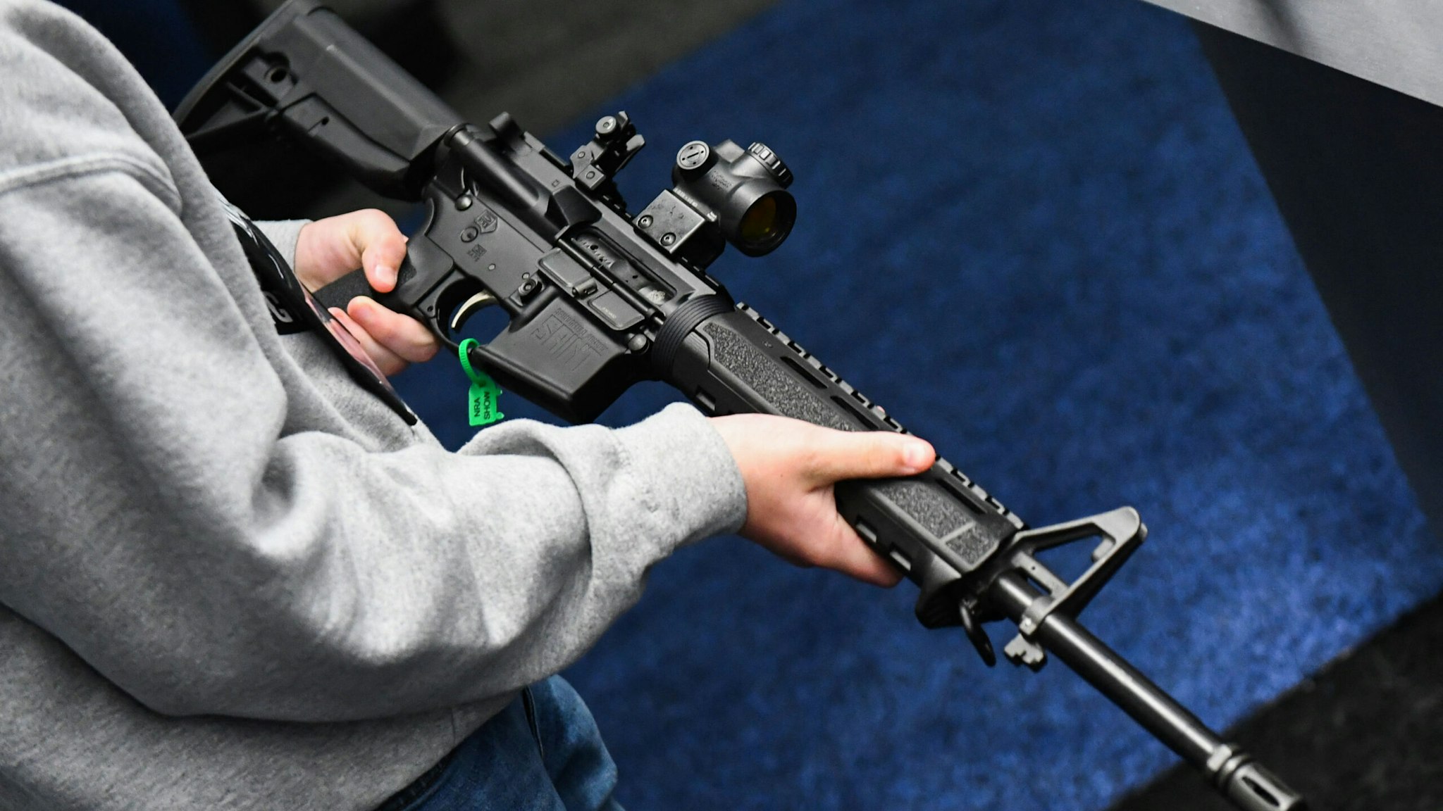 An attendee holds a Springfield Armory SAINT AR-15 style rifle displayed during the National Rifle Association (NRA) Annual Meeting at the George R. Brown Convention Center, in Houston, Texas on May 28, 2022. - America's powerful National Rifle Association kicked off a major convention in Houston Friday, days after the horrific massacre of children at a Texas elementary school, but a string of high-profile no-shows underscored deep unease at the timing of the gun lobby event.