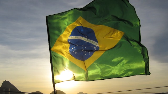 A flag flies on Copacabana Beach at sunrise in Rio de Janeiro, Brazil, June 8, 2014.