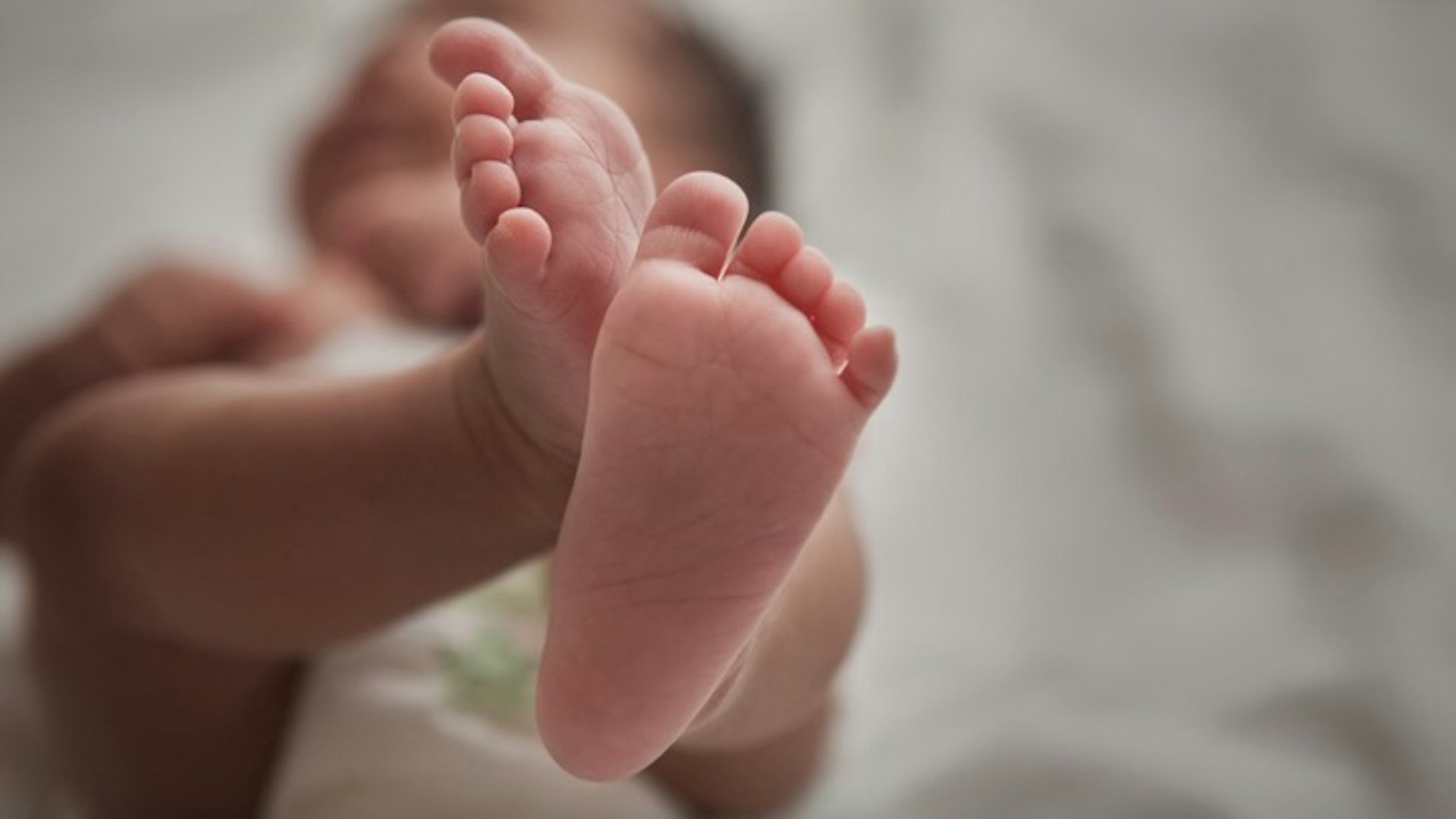 Close up of mixed race newborn baby girl's feet - stock photo Jose Luis Pelaez Inc via Getty Images