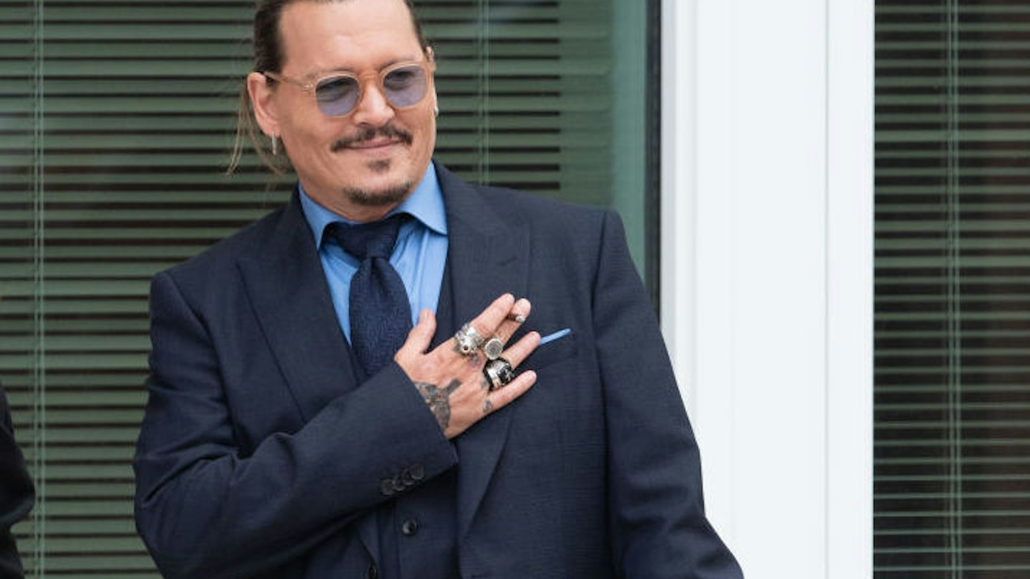 Johnny Depp gestures to fans during a recess outside court during the Johnny Depp and Amber Heard civil trial at Fairfax County Circuit Court on May 27, 2022 in Fairfax, Virginia.