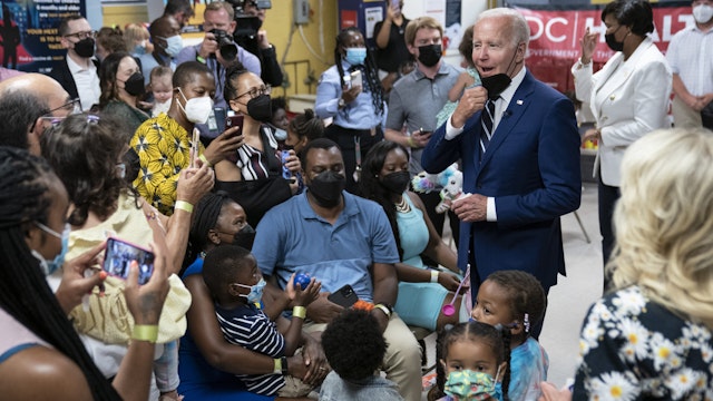 US President Joe Biden speaks with families while visiting a Covid-19 vaccination clinic hosted by the District of Columbia's Department of Health in Washington