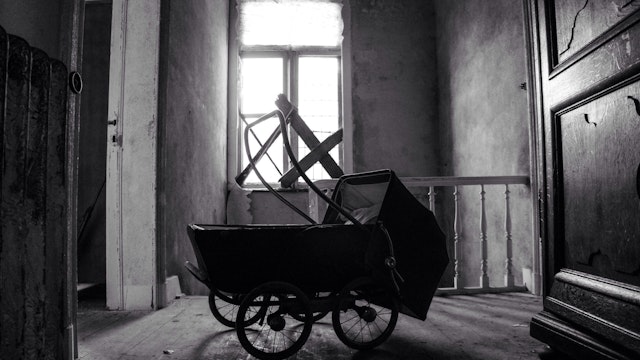 Side view of pram in an empty room - stock photo