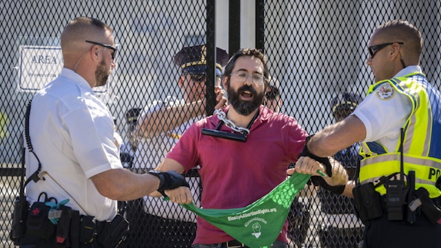 Abortion-rights activist Guido Reichstadter is confronted and detained by Supreme Court Police officers after chaining himself to a security fence in front of the U.S. Supreme Court on June 6, 2022 in Washington, DC.