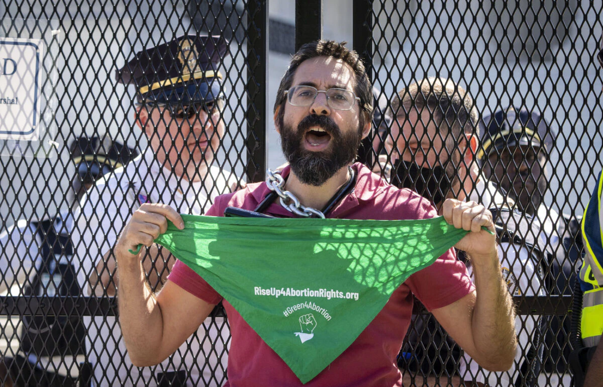 Abortion-rights activist Guido Reichstadter is confronted and detained by Supreme Court Police officers after chaining himself to a security fence in front of the U.S. Supreme Court on June 6, 2022 in Washington, DC.