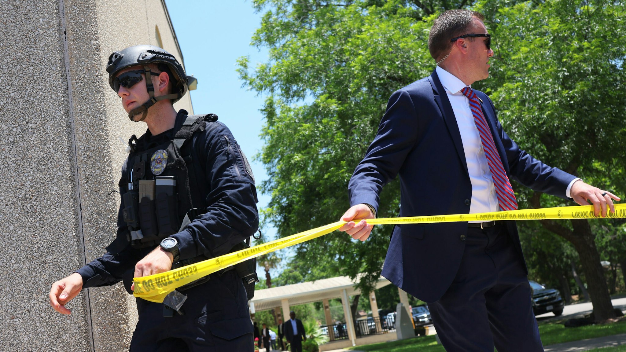 UVALDE, TEXAS - MAY 28: Law enforcement officials put up caution tape as President Joe Biden attends mass at Sacred Heart Catholic Church on May 29, 2022 in Uvalde, Texas. On May 24th, 19 children and two adults were killed during a mass shooting at Robb Elementary School after a gunman entered the school through an unlocked door and barricaded himself in a classroom where the victims were located.