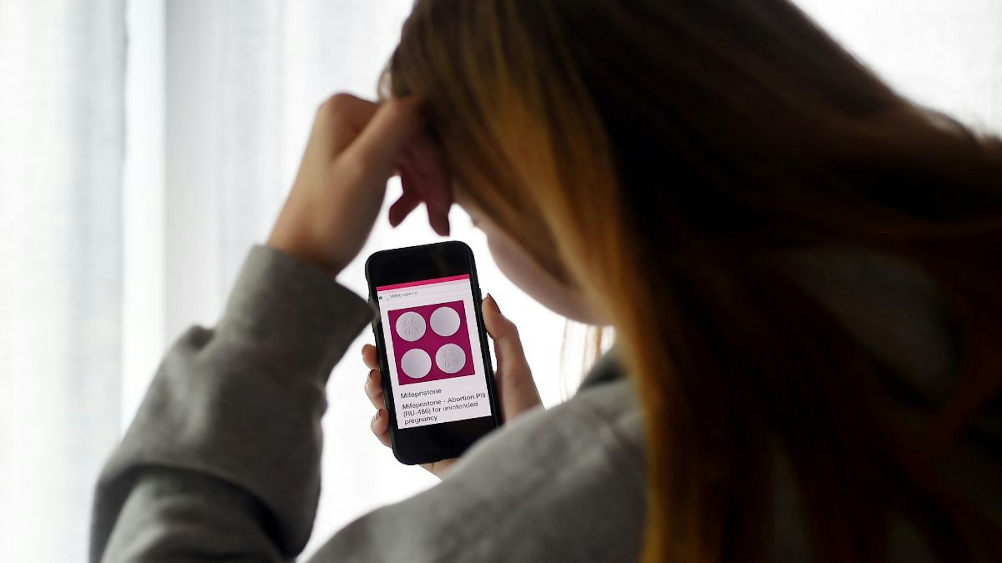 In this photo illustration, a person looks at an Abortion Pill (RU-486) for unintended pregnancy from Mifepristone displayed on a smartphone on May 8, 2020, in Arlington, Virginia.