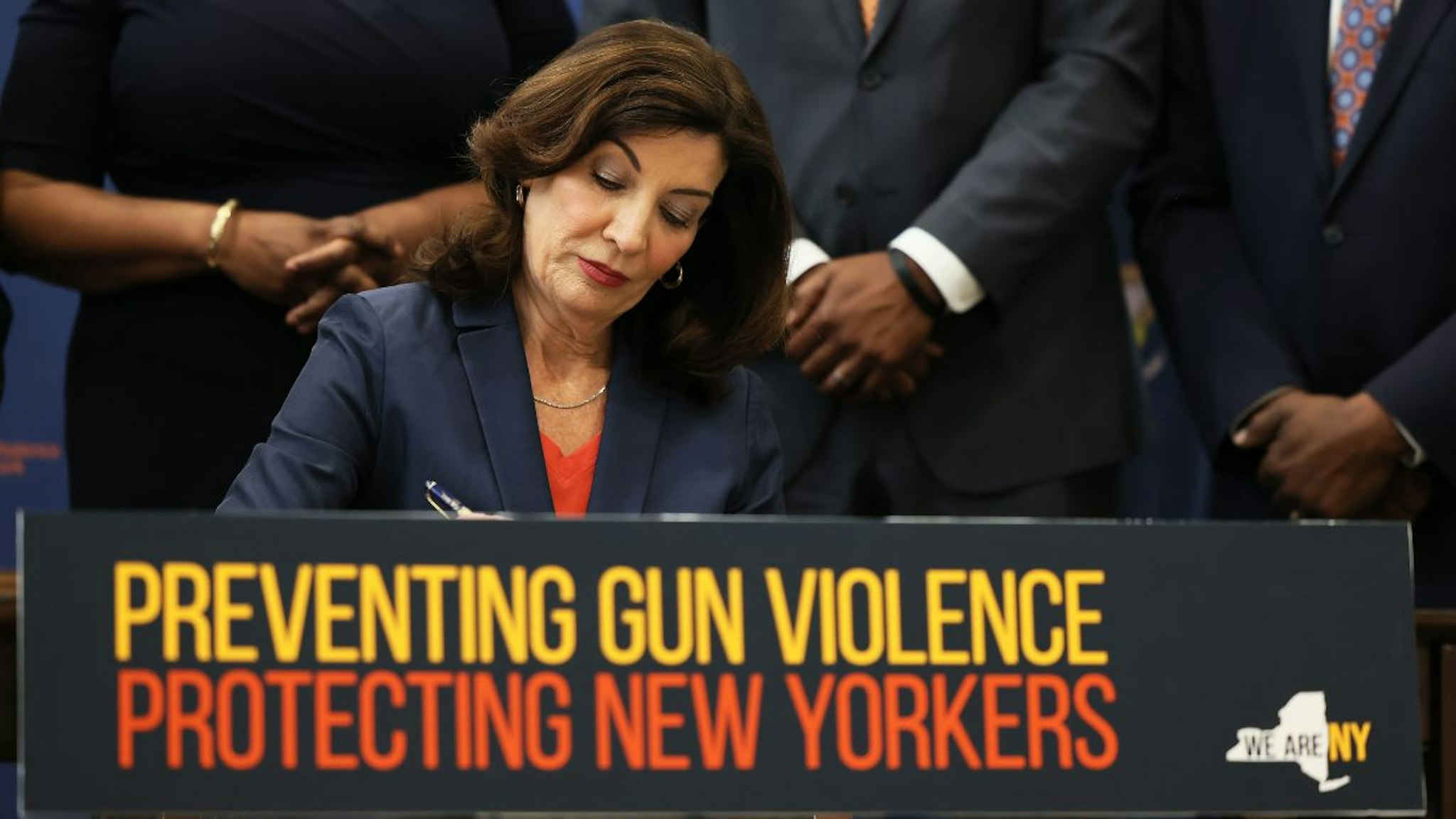 Gov. Kathy Hochul signs legislation as she is surrounded by lawmakers during a bill signing ceremony at the Northeast Bronx YMCA on June 06, 2022 in New York City.