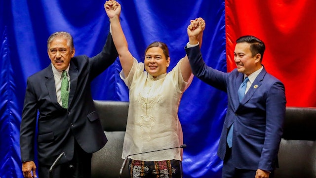 Vice President-elect Sara Duterte-Carpio C raises hands with the Senate president Vicente Sotto L and the House speaker Allan Velasco during her proclamation at the Philippine House of Representatives in Quezon City, the Philippines, on May 25, 2022.