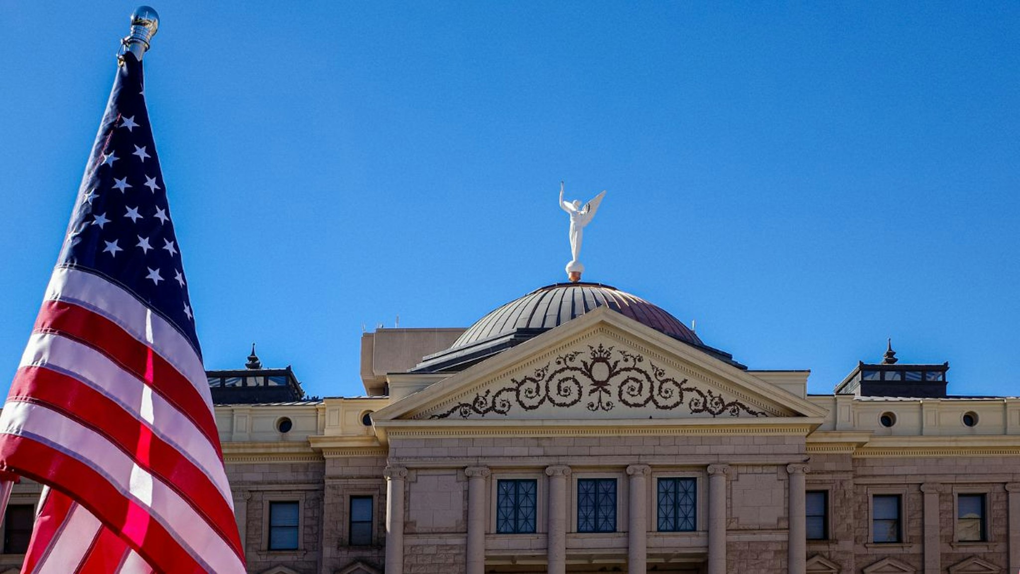 A Boogaloo Boys movement flag, right, outside the Arizona State Capitol in Phoenix, Arizona, U.S., on Wednesday, Jan. 6, 2021.