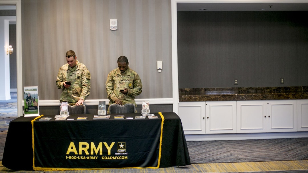 U.S. Army recruiters view mobile devices during a National Career Fairs event in Dearborn, Michigan, U.S., on Tuesday, Dec. 5, 2017.
