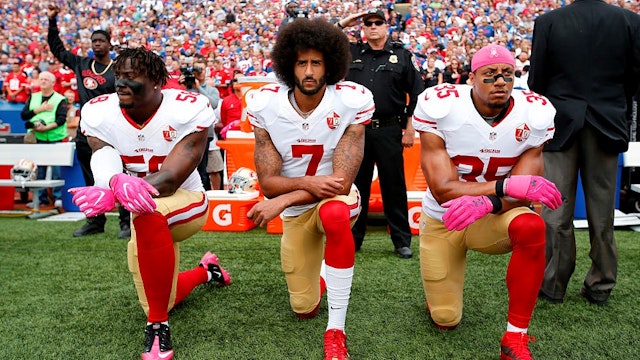 ORCHARD PARK, NY - OCTOBER 15: Eli Harold #58, Colin Kaepernick #7 and Eric Reid #35 of the San Francisco 49ers kneel in protest on the sideline, during the anthem, prior to the game against the Buffalo Bills at New Era Field on October 16, 2016 in Orchard Park, New York. The Bills defeated the 49ers 45-16. (Photo by