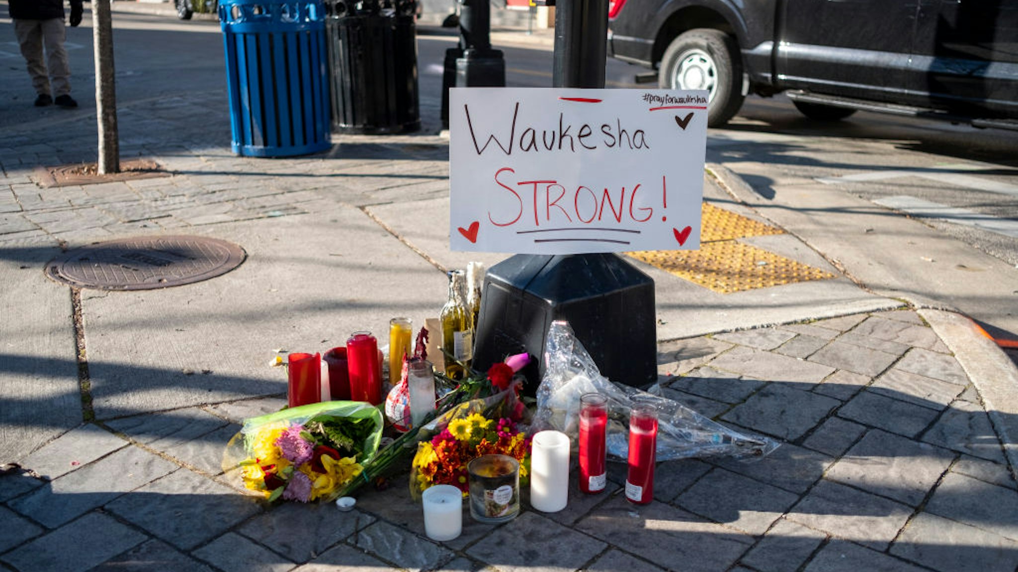 WAUKESHA, WI - NOVEMBER 23: Memorials placed along Main Street in downtown Waukesha Wisconsin left in areas where people were hit by a driver plowing into the Christmas parade on Main Street in downtown November 22, 2021 in Waukesha, Wisconsin. Five people were left dead after a person driving an S.U.V. entered the parade route and proceeded to strike dozens of people.