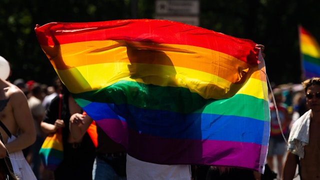 a member of LGBT community holds a rainbow flag during annual CSD pride parade in Cologne, Germany on July 3, 2022 as a million people take part in this year parade.