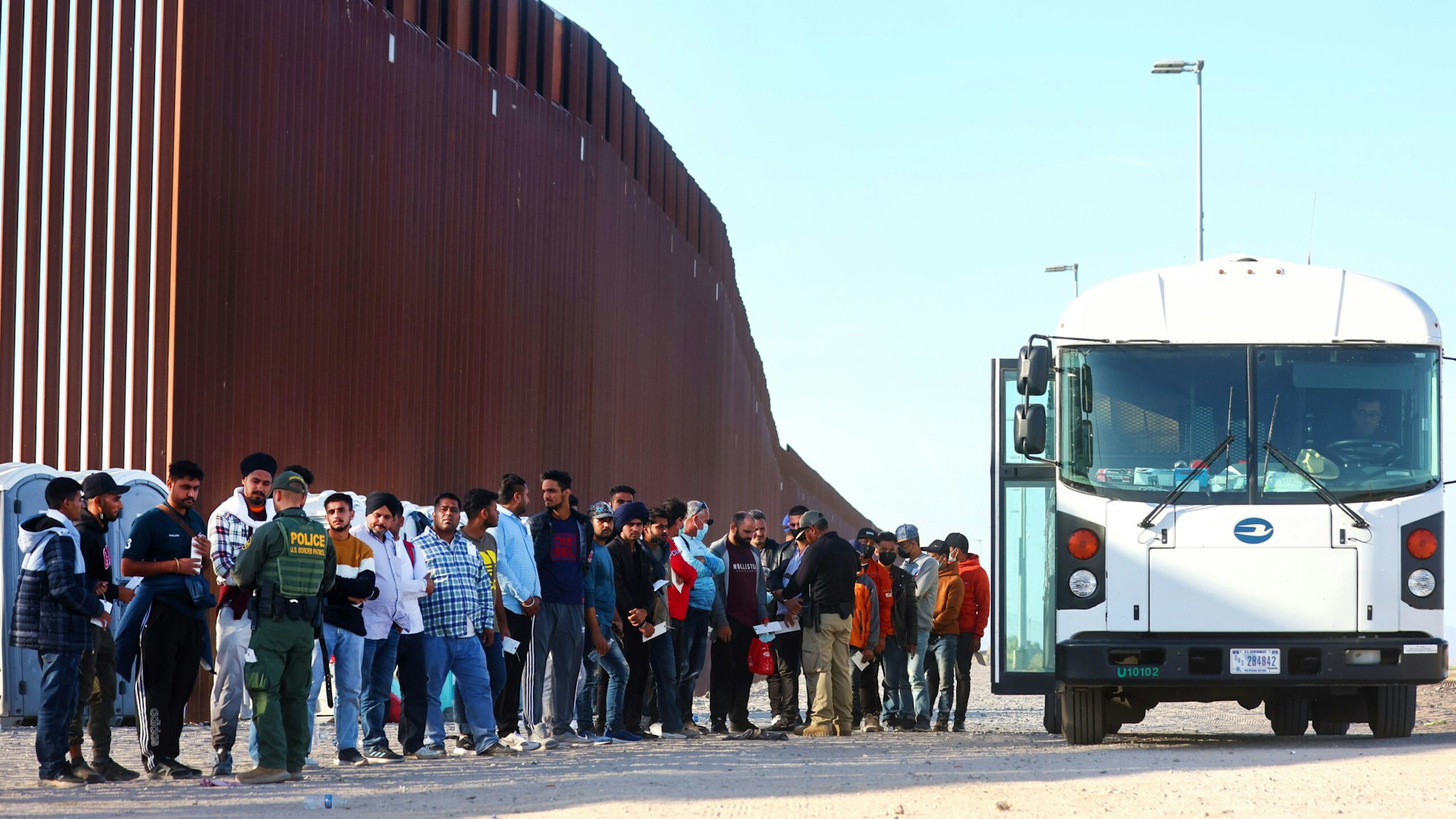 YUMA, ARIZONA - MAY 19: Immigrants wait to board a U.S. Border Patrol bus to be taken for processing after crossing the border from Mexico on May 19, 2022 in Yuma, Arizona. Title 42, the controversial pandemic-era border policy enacted by former President Trump, which cites COVID-19 as the reason to rapidly expel asylum seekers at the U.S. border, is set to officially expire on May 23rd. A federal judge in Louisiana is expected to deliver a ruling this week on whether the Biden administration can lift Title 42.
