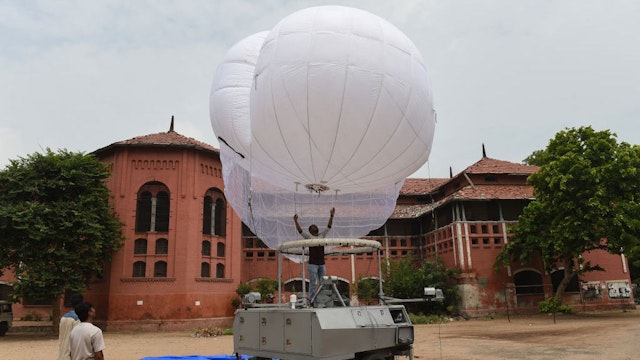 Indian technicians from Tata Power and Indian Border Security Force (BSF) assemble an Israeli-made surveillance Aerostat Balloon in Ahmedabad on July 13, 2018. - The Aerostat Balloon, which reaches a height of 250 metres and provides surveillance over a 5km radius, is set to be used in Ahmedabad for the annual religious Rath Yatra chariot procession on July 14, backed by thousands of Gujarati police and paramilitary security personnel. (Photo by SAM PANTHAKY / AFP) (Photo credit should read SAM PANTHAKY/AFP via Getty Images)