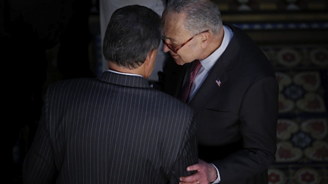 Sen. Joe Manchin (D-WV) (L) talks with Senate Majority Leader Charles Schumer (D-NY) before the ceremony where U.S. President Joe Biden signed the “Consolidated Appropriations Act" in the Eisenhower Executive Office Building on March 15, 2022 in Washington, DC