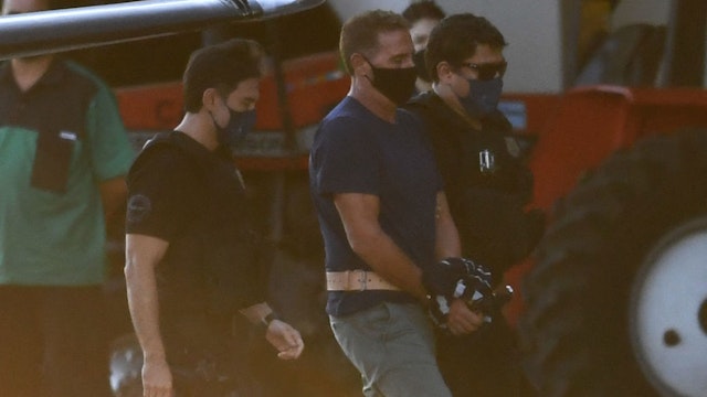 Italian Rocco Morabito, wanted for drug trafficking and mafia activities, arrives to Brasilia on May 25, 2021 escorted by federal police and interpol agents after being arrested yesterday in Joao Pessoa, in the state of Paraiba, northeastern Brazil. - Italian prosecutors and police on Tuesday cheered the capture in Brazil of a leading mafia boss who has skirted justice in Italy for nearly 30 years. (Photo by EVARISTO SA / AFP) (Photo by EVARISTO SA/AFP via Getty Images)