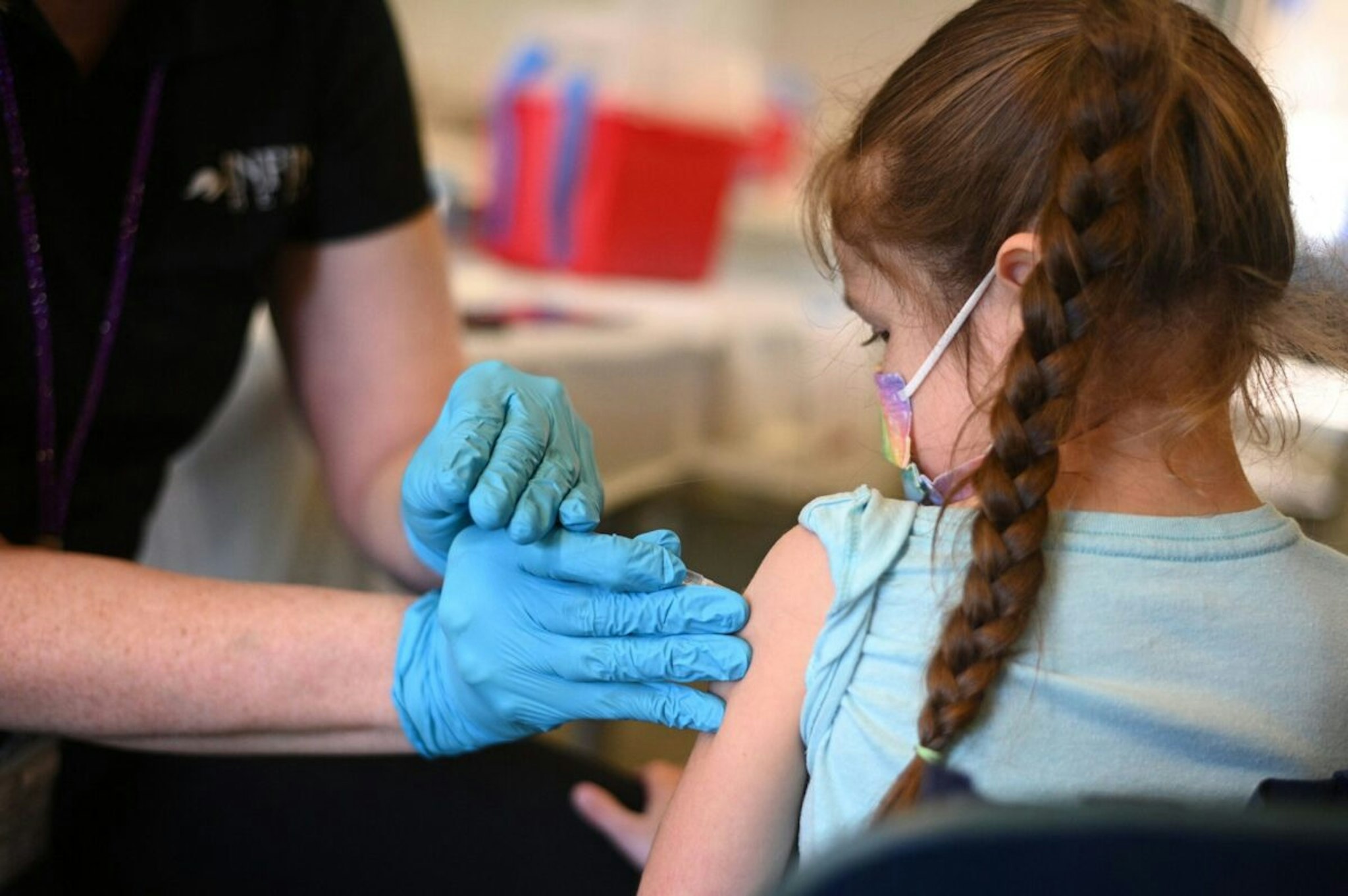 A nurse administers a pediatric dose of the Covid-19 vaccine to a girl at a L.A. Care Health Plan vaccination clinic at Los Angeles Mission College in the Sylmar neighborhood in Los Angeles, California, January 19, 2022. - While cases of Covid-19 hospitalizations and deaths continue to rise in California, officials are seeing early signs that the Omicron surge is slowing. (Photo by Robyn Beck / AFP) (Photo by ROBYN BECK/AFP via Getty Images)