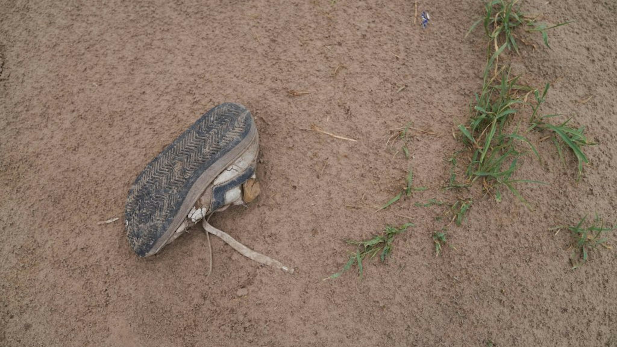 A shoe left behind by a migrant is seen along the Rio Grande River in Eagle Pass, Texas, on May 22, 2022.