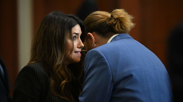 Attorney Camille Vasquez speaks with actor Johnny Depp in the courtroom at the Fairfax County Circuit Courthouse in Fairfax, Virginia, on May 24, 2022. - Actor Johnny Depp is suing ex-wife Amber Heard for libel after she wrote an op-ed piece in The Washington Post in 2018 referring to herself as a public figure representing domestic abuse. (Photo by JIM WATSON / POOL / AFP) (Photo by JIM WATSON/POOL/AFP via Getty Images)
