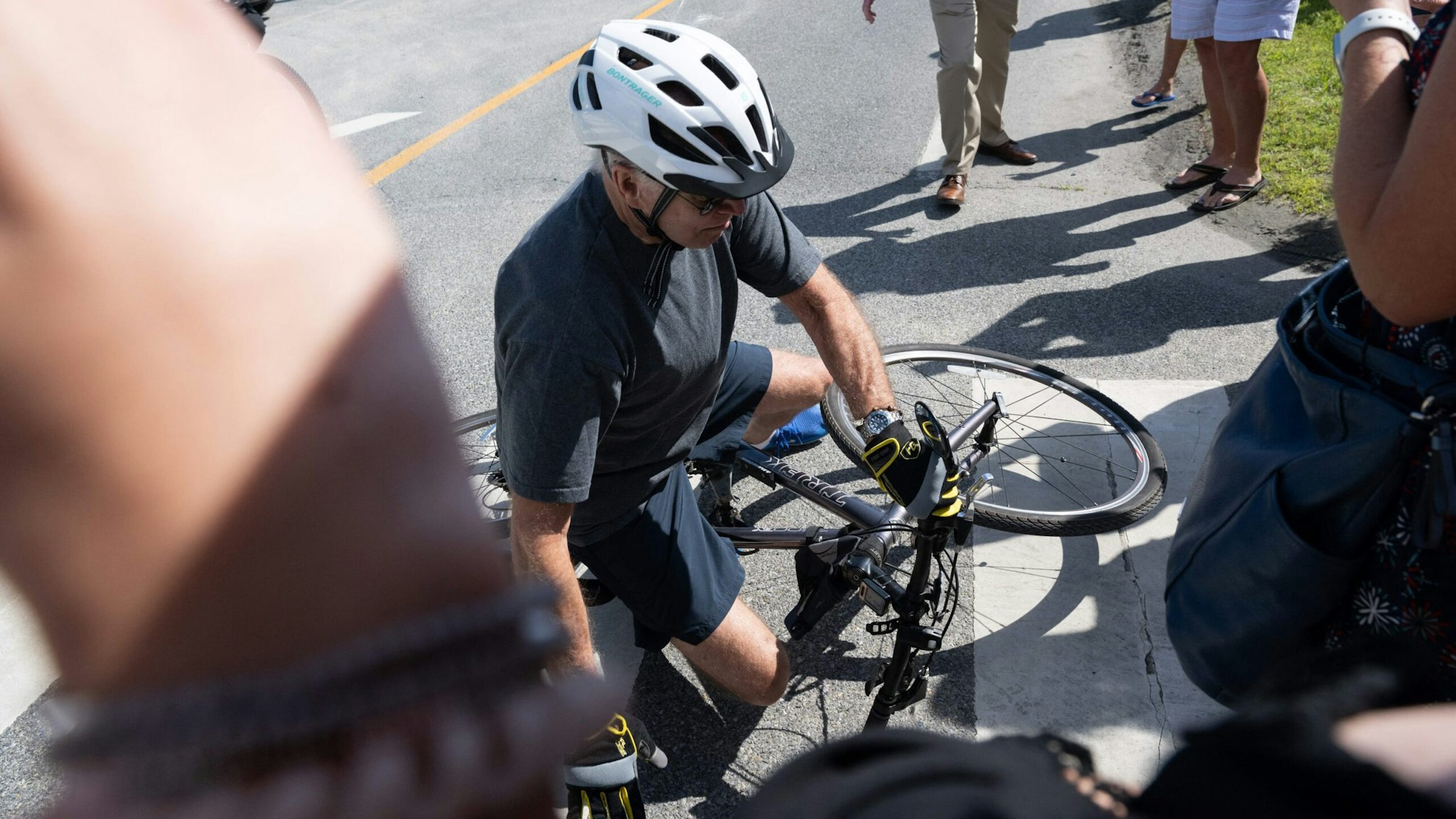 President Joe Biden falls off his bicycle as he approaches well-wishers following a bike ride at Gordon's Pond State Park in Rehoboth Beach, Delaware, on June 18, 2022.