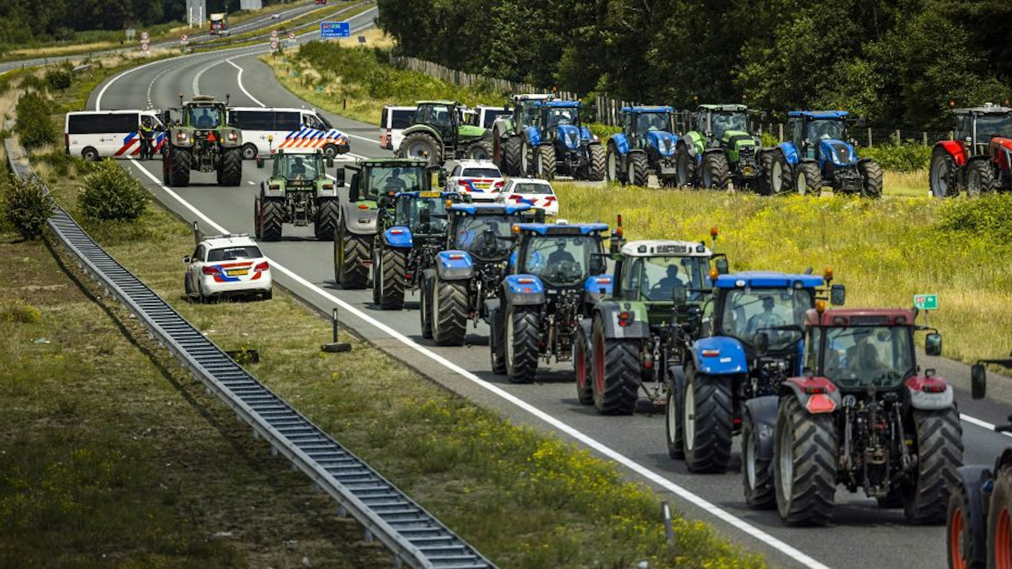 Farmers take part in a blockade of the A67 near Eindhoven to protest against government plans that may require them to use less fertilizer and reduce livestock at Hapert, on July 4, 2022. - Netherlands OUT (Photo by ROB ENGELAAR / ANP / AFP) / Netherlands OUT (