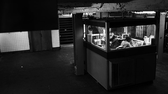 A subway station attendant sits in a booth of the Kingston-Throop Ave. station, where MTA worker Harry Kaufman was killed November 26, 1995, after being attacked with gasoline and fire in a botched robbery at the token booth in Bedford-Stuyvesant on May 16, 2013 in Brooklyn borough of New York City.