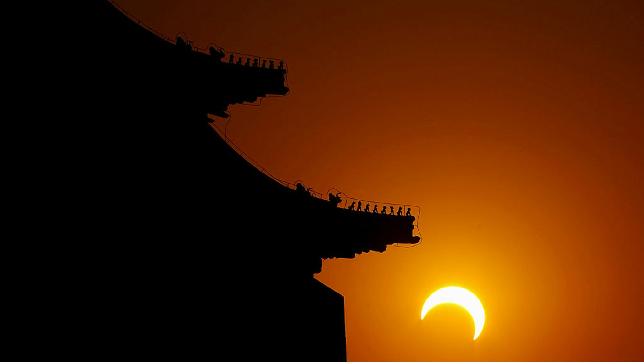 BEIJING - JANUARY 15: The moon begins to obstruct the view of the sun from earth during a soloar eclipse at the Tian'anmen Square on January 15, 2010 in Shenyang, Liaoning Province of China. The eclipse, which first became visible in Tamil Nadu city of Kanyakumari, is predicted to be the longest of its kind for the next 1000 years. (Photo by