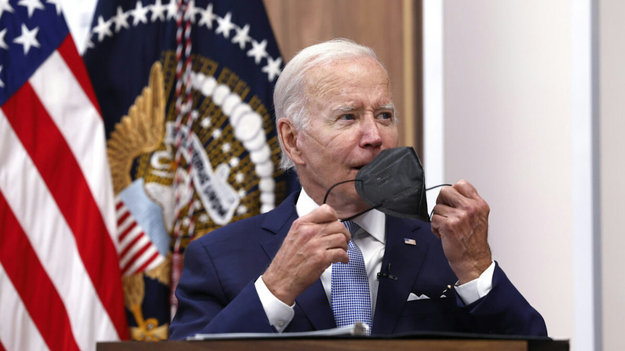 U.S. President Joe Biden takes his face mask off during a meeting on the U.S. Economy with CEOs and members of his Cabinet in the South Court Auditorium of the White House on July 28, 2022 in Washington, DC