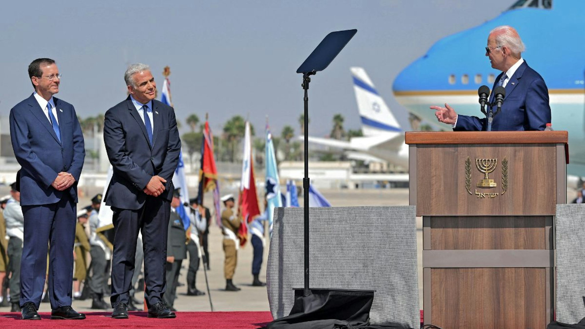 Israel's President Isaac Herzog (L) and caretaker Prime Minister Yair Lapid (C) listen to US President Joe Biden (R) as he addresses his hosts upon his arrival at Ben Gurion Airport in Lod near Tel Aviv, on July 13, 2022.