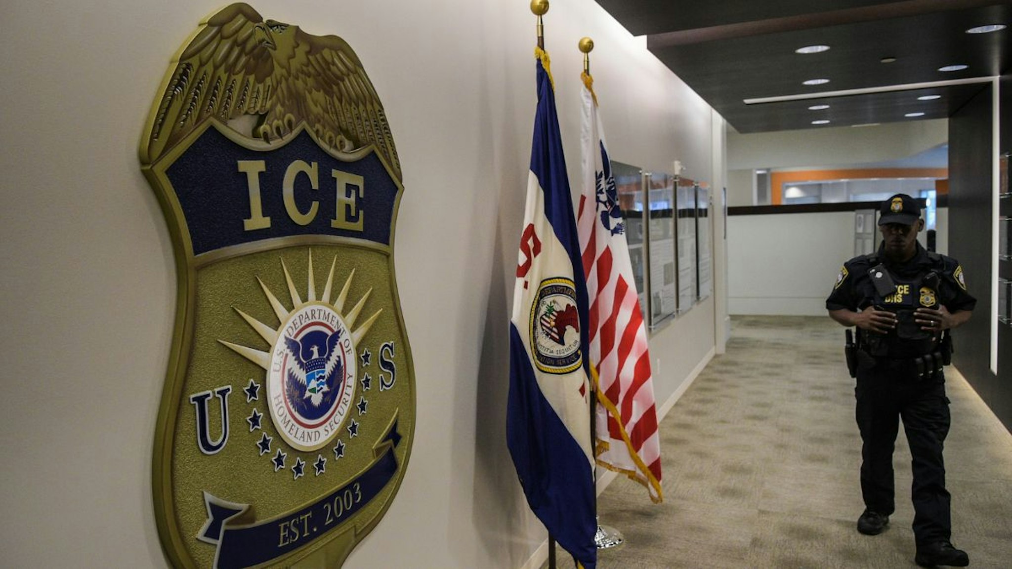 A law enforcement officer walks past ICE logo ahead of a press conference on Thursday, May 11, 2017, at the U.S. Immigration and Customs Enforcement headquarters in Washington, DC.
