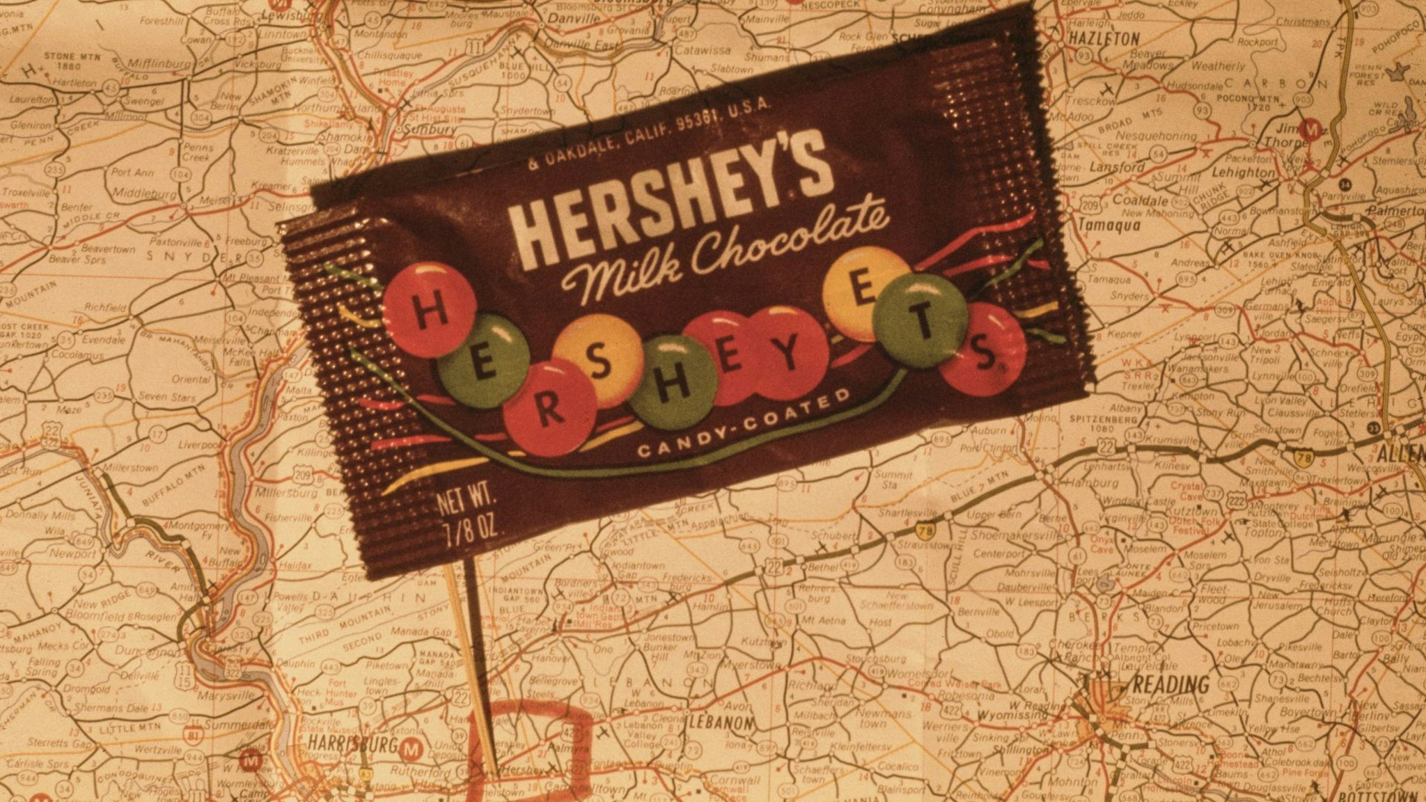 A packet of candy-coated Hershey's milk chocolate on a map of Pennsylvania, showing the location of the original Hershey chocolate factory in Hershey, Derry Township, USA, just east of Harrisburg, November 1969.