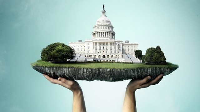 U.S. capitol building on chunk of land being held up by hands