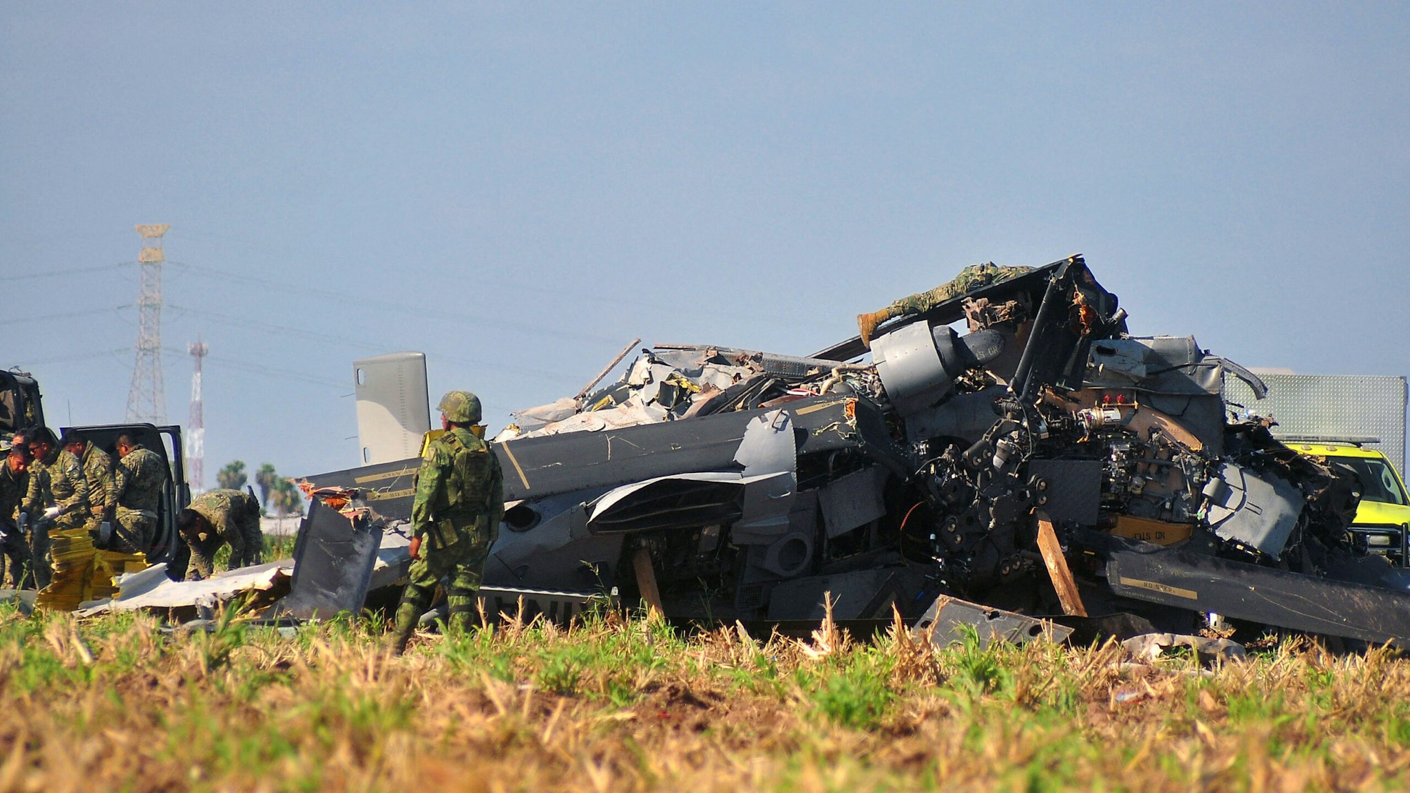 Soldiers of the Mexican Army inspect the wreckage of a Navy helicopter that crashed near the airport of Los Mochis, Sinaloa State, Mexico on July 15, 2022. - Fourteen people were killed when the military helicopter crashed on Friday in northwestern Mexico, the navy said. "A Black Hawk helicopter was involved in an accident, the cause of which is unknown at this time," a statement said. It said the aircraft was carrying 15 people and the sole survivor was receiving medical treatment after the crash in the state of Sinaloa.