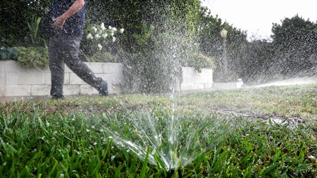 Los Angeles Department of Water and Power (LADWP) water conservation specialist Damon Ayala walks while inspecting a sprinkler system, which is operating in violation of the water conservation ordinance, on July 27, 2022 in Los Angeles, California.