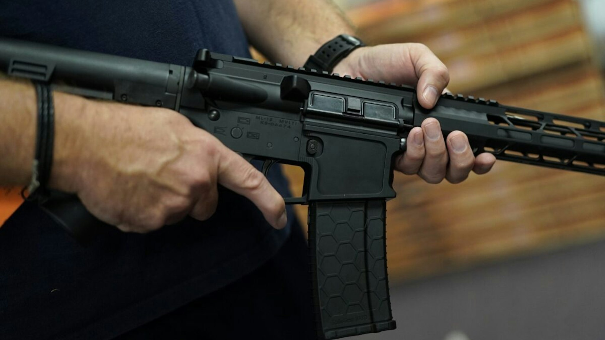 A customer handles an AR-15 at Jimmy's Sport Shop in Mineola, New York on September 25, 2020