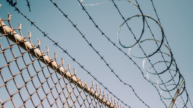 Barbed Wire Fence with Razor Wire: Security, Protection and Exclusion - stock photo High security fence in prohibited area: chain link fence with barbed wire and razor wire. Conceptual image for danger, exclusion and protection. Jena Ardell via Getty Images
