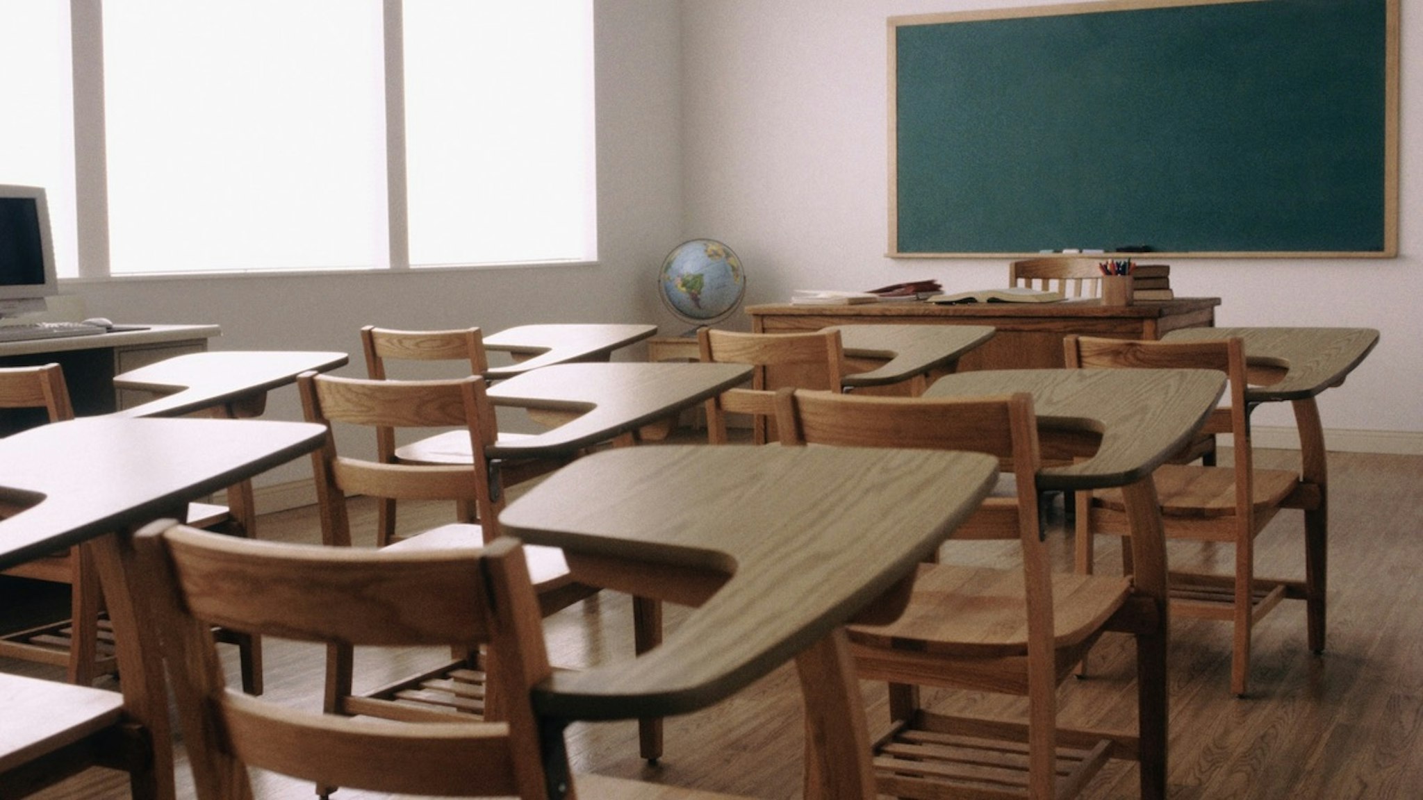Empty desk in elementary school classroom - stock photo Rob Lewine via Getty Images