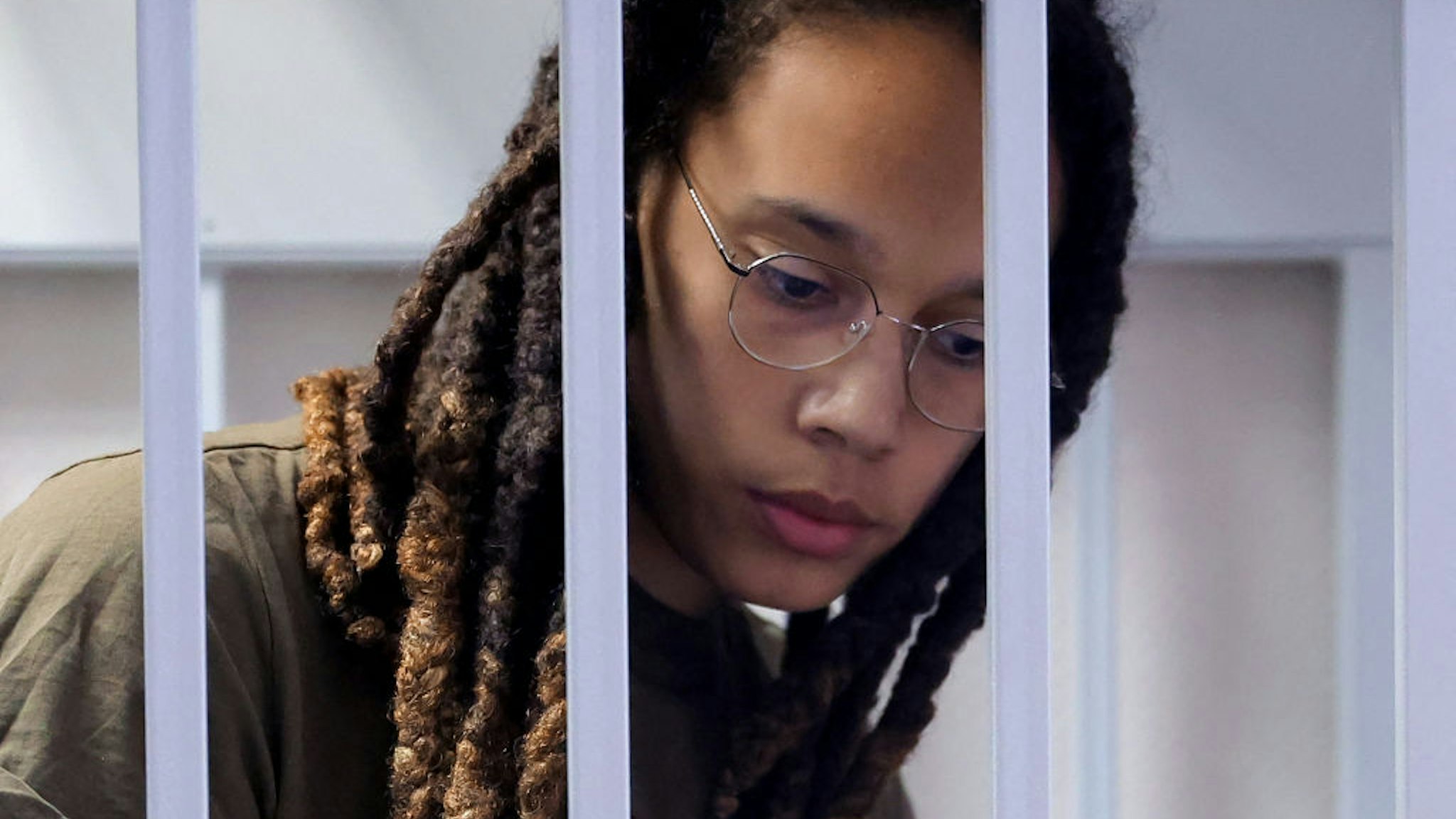 US basketball player Brittney Griner stands in a defendants' cage before a court hearing during her trial on charges of drug smuggling, in Khimki, outside Moscow on August 2, 2022