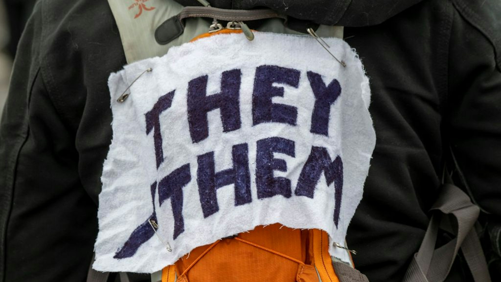 A protestor wears a piece of fabric with the pronouns 'they/them' pinned to them as Minneasotans hold a rally to raise awareness of the increasing number of attacks on transgender children, at the Capitol in the St Paul area of Minnesota, Texas, 6th March 2022. (Photo by: Michael Siluk/UCG/Universal Images Group via Getty Images)