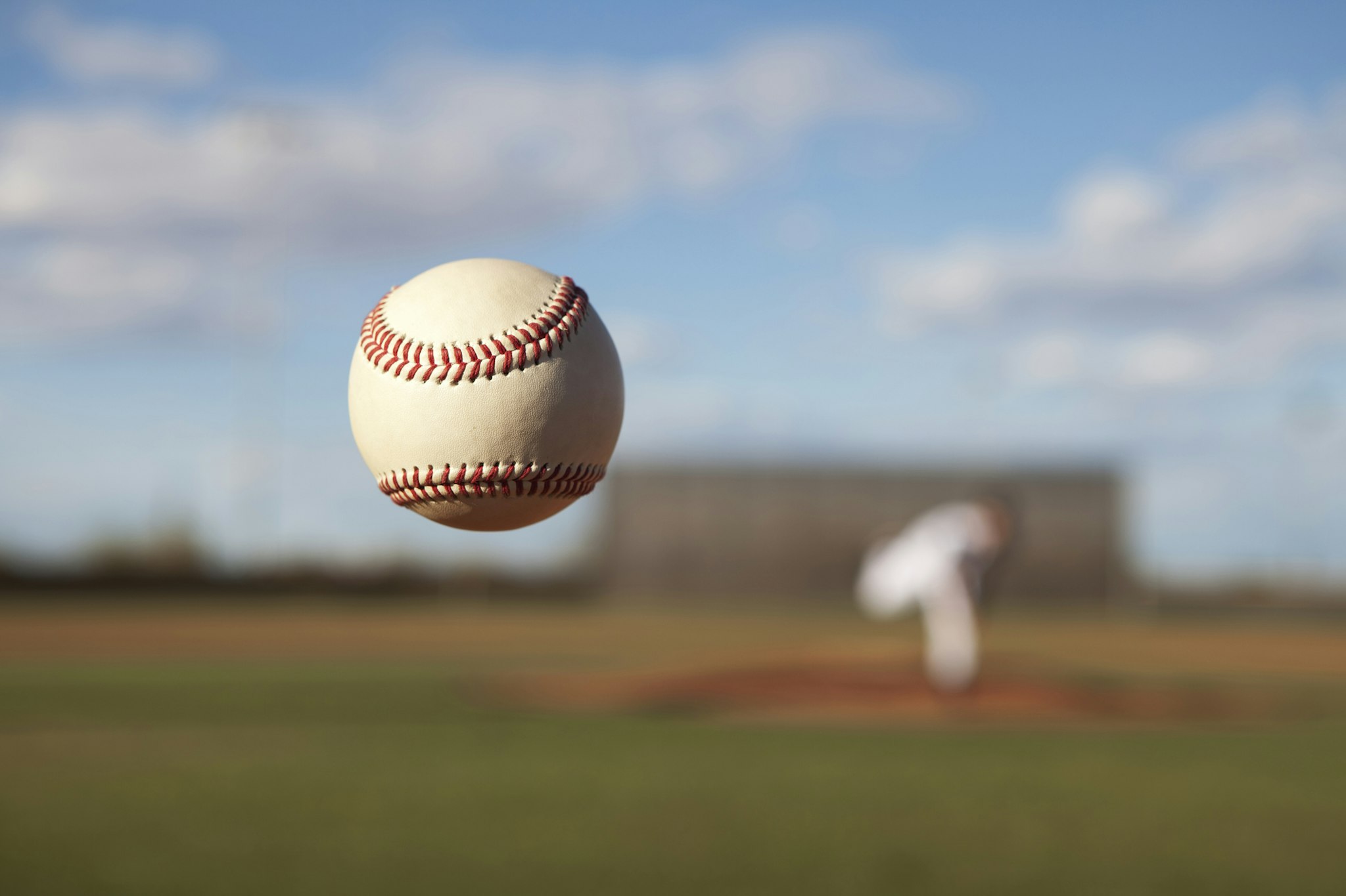The dancing knuckleball pitch slowly approaches the plate in the summer sport of Baseball.
