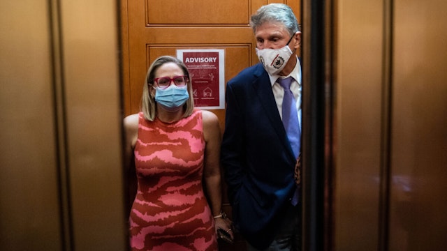 Sen. Kyrsten Sinema (D-AZ) and Sen. Joe Manchin (D-WV) catch and an elevator to go to the Senate Chamber to vote, after meeting in Sen. Manchins hideaway for half an hour, in the U.S. Capitol on Thursday, Sept. 30, 2021 in Washington, DC