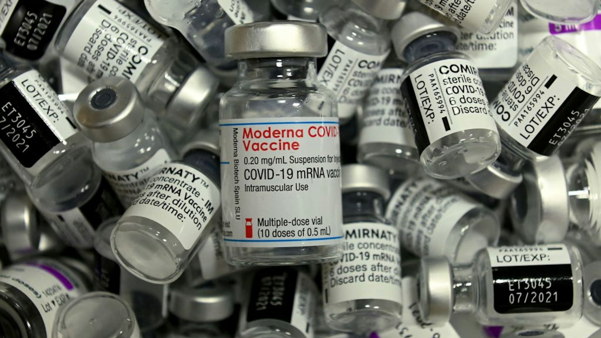 Empty vials of different vaccines by Moderna, Pfizer-BioNTech and AstraZeneca against Covid-19 caused by the novel coronavirus are pictured at the vaccination center in Rosenheim, southern Germany, on April 20, 2021, amid the novel coronavirus / COVID-19 pandemic.