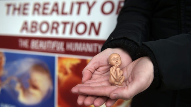 A Pro Life campaigner displays a plastic doll representing a 12 week old foetus as she stands outside the Marie Stopes Clinic on April 7, 2016 in Belfast, Northern Ireland