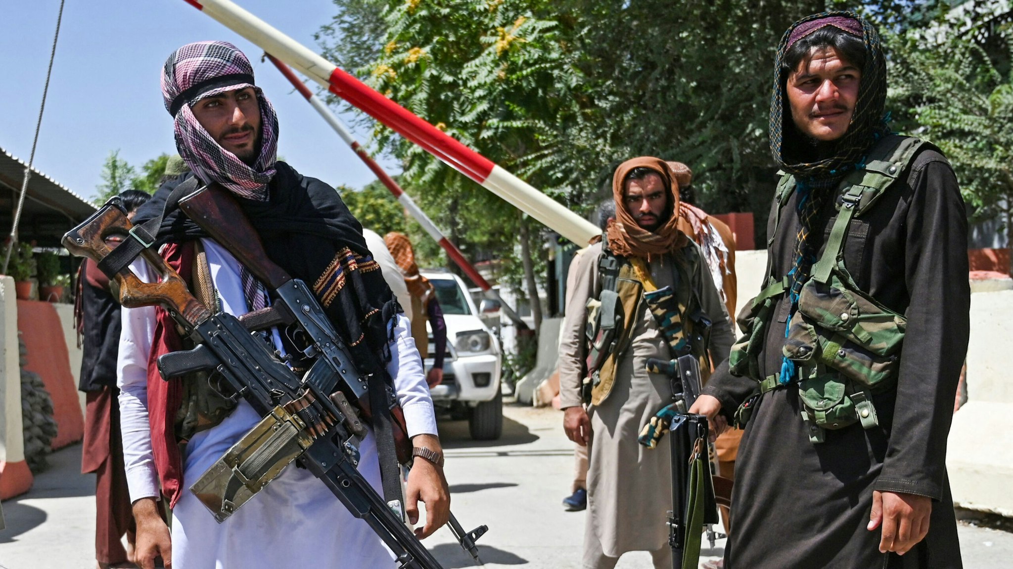TOPSHOT - Taliban fighters stand guard along a roadside near the Zanbaq Square in Kabul on August 16, 2021, after a stunningly swift end to Afghanistan's 20-year war, as thousands of people mobbed the city's airport trying to flee the group's feared hardline brand of Islamist rule.