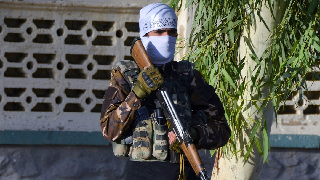 A Taliban fighter stands guard outside a public meeting held at a private salon in Kandahar on August 18, 2022.
