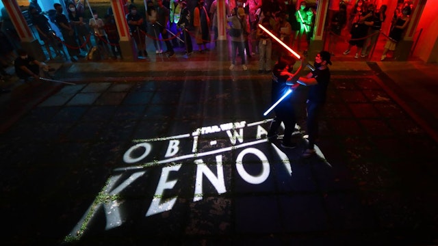 Two men engage in a lightsaber duel in conjunction with the new Star Wars series premiere of Obi-Wan Kenobi on Disney+ on May 27, 2022 in Singapore.