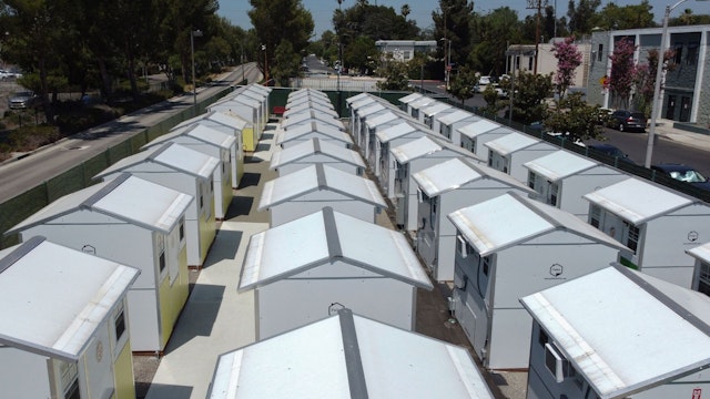 TOPSHOT - A view of housing units at the Tarzana Tiny Home Village which offers temporary housing for homeless people, is seen onJuly 9, 2021 in the Tarzana neighborhood of Los Angeles, California. - The habitats are very small prefabricated houses, installed in a parking lot in Los Angeles.
