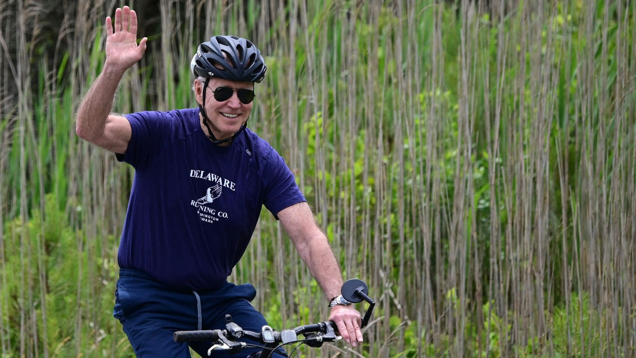 TOPSHOT - US President Joe Biden rides his bicycle in Cape Henlopen State Park on June 3, 2021, in Lewes, Delaware.