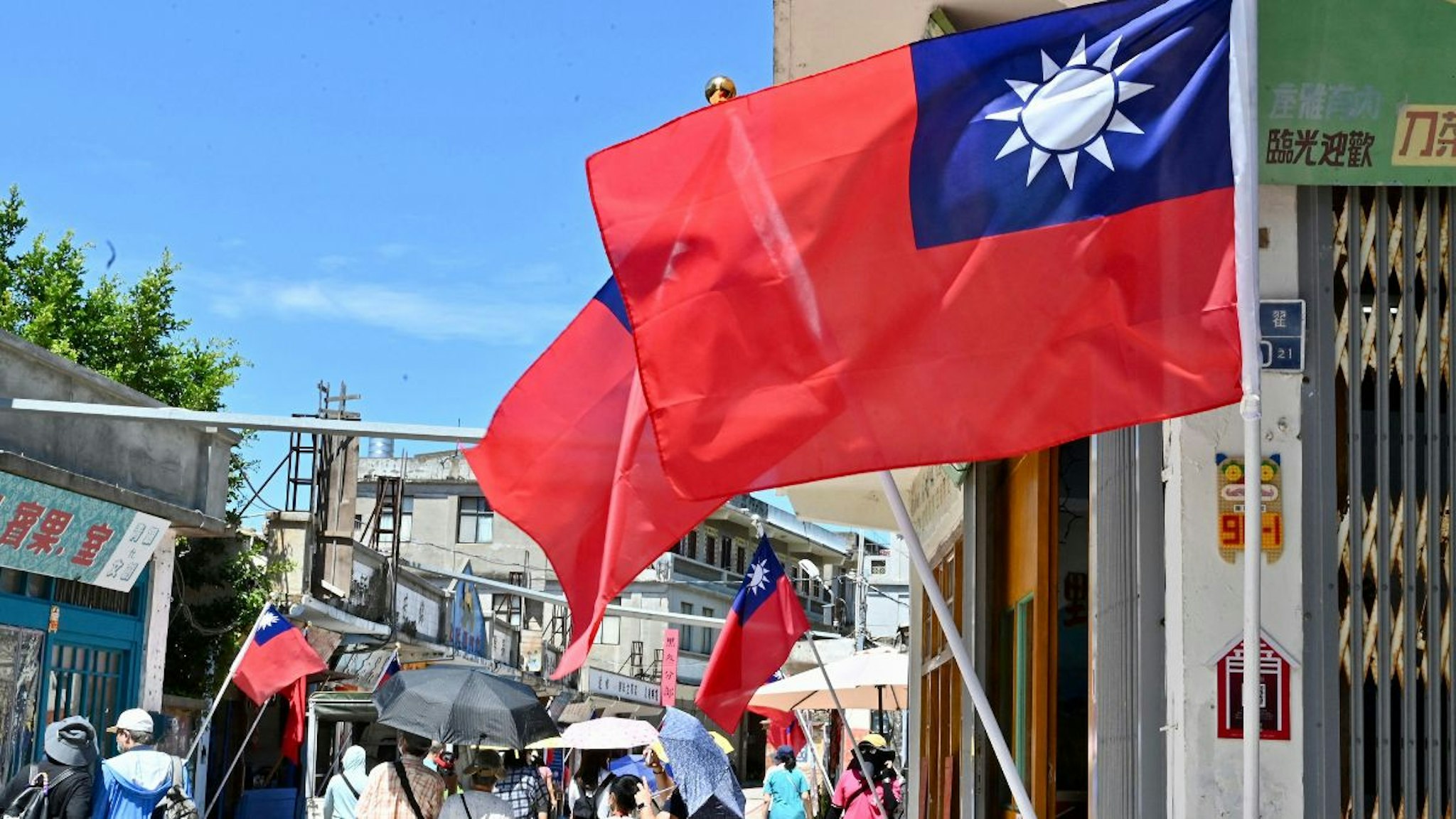 Taiwanese flags are seen as tourists walk past in Taiwan's Kinmen islands on August 11, 2022.